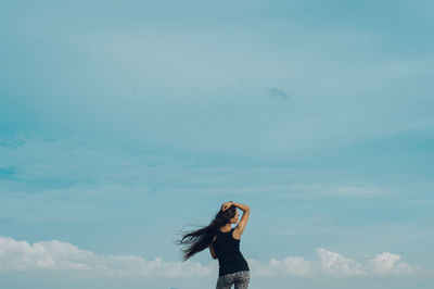 Young woman against blue sky