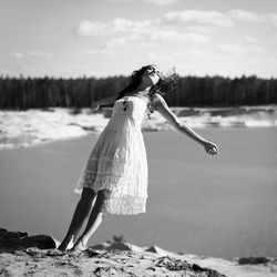 Woman falling in lake against sky