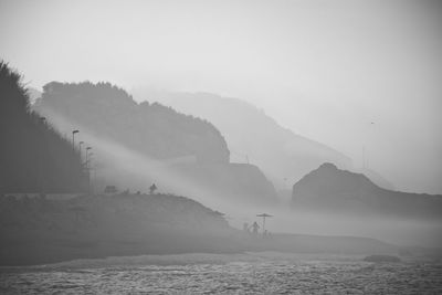 Scenic view of sea and mountains against sky