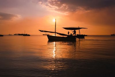 Silhouette boat in sea against sky during sunset