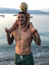 Portrait of shirtless man standing at beach