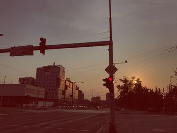 Road sign on street in city against sky