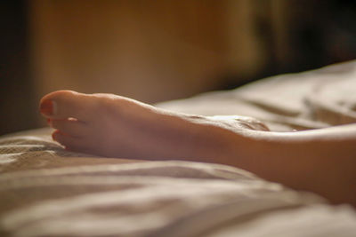 Warm woman's foot on a bed