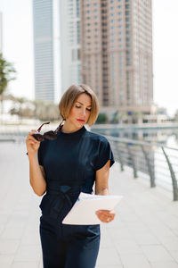 A business woman looks through documents during a break on the street