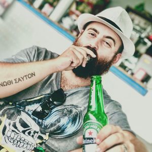 Portrait of young man drinking beer in bottle