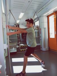 Side view of a smiling boy standing in corridor