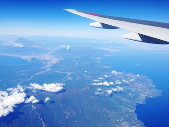 Cropped image of airplane wing over landscape