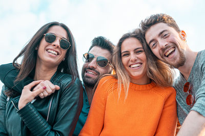 Portrait of smiling friends against sky