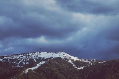 Scenic view of snow covered mountains against cloudy sky