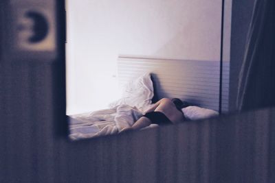 Person on bed reflecting in mirror at home