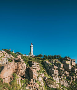 Low angle view of lighthouse against clear blue sky