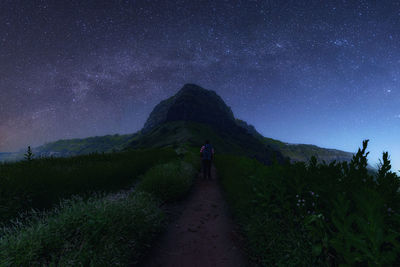 Rear view of man on field against night sky