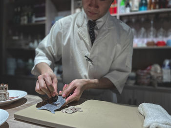 Midsection of man working on table