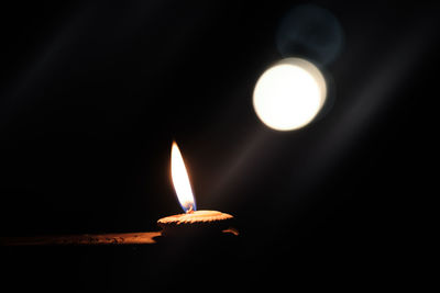 Close-up of burning candle in the dark