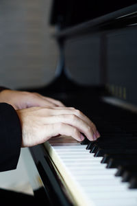 Cropped hands playing piano