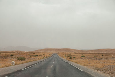 Empty road in desert against clear sky