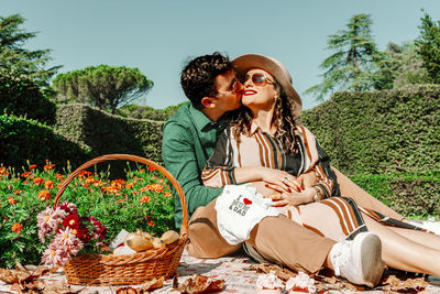 Man kissing pregnant woman at park