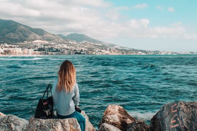 Rear view of woman looking at sea against sky