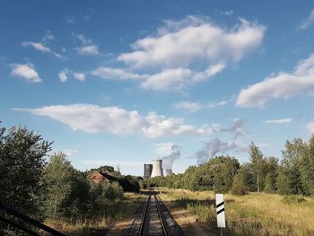 Railroad tracks in city against sky