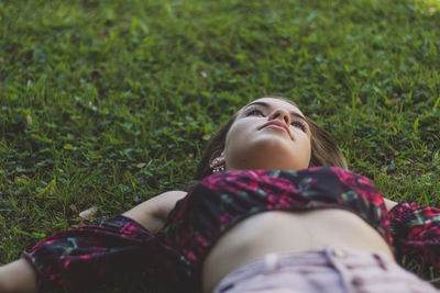 Teenage girl lying down on grass