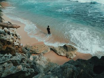 High angle view of waves breaking on rocks at beach