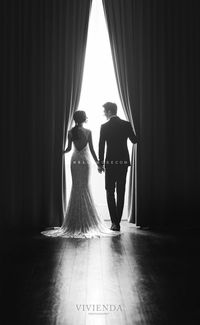 Rear view of women standing in corridor