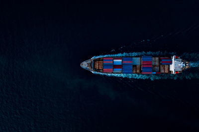 Containers ship corgo logistic transportation import export international sailing top speed in dark