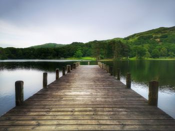 Wooden pier over lake against sky