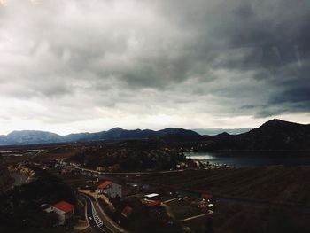 High angle view of townscape by mountains against sky