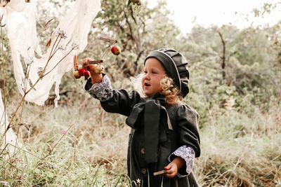 Full length of boy holding apple on field