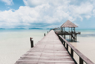 Wooden pier on sea against sky