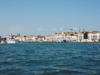 Scenic view of sea by buildings against clear sky