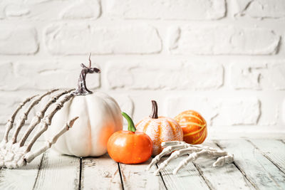 Close-up of pumpkins on table against wall