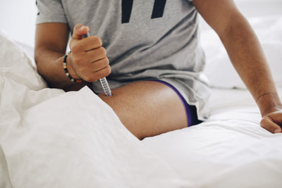 Midsection of woman lying on bed