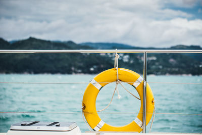 Close-up of yellow boat sailing on sea against sky