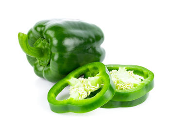 Close-up of green bell peppers against white background