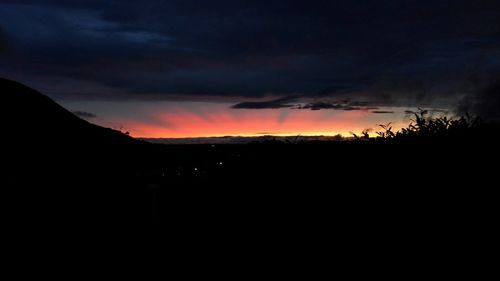 Scenic view of dramatic sky over silhouette landscape