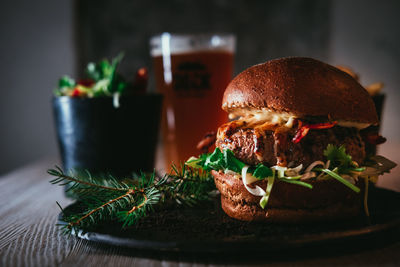 Close-up of burger with beer glass on table