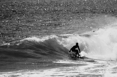 Man surfing in sea against sky