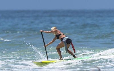 Woman paddleboarding in sea