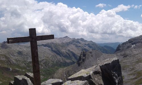 Cross on mountain against sky