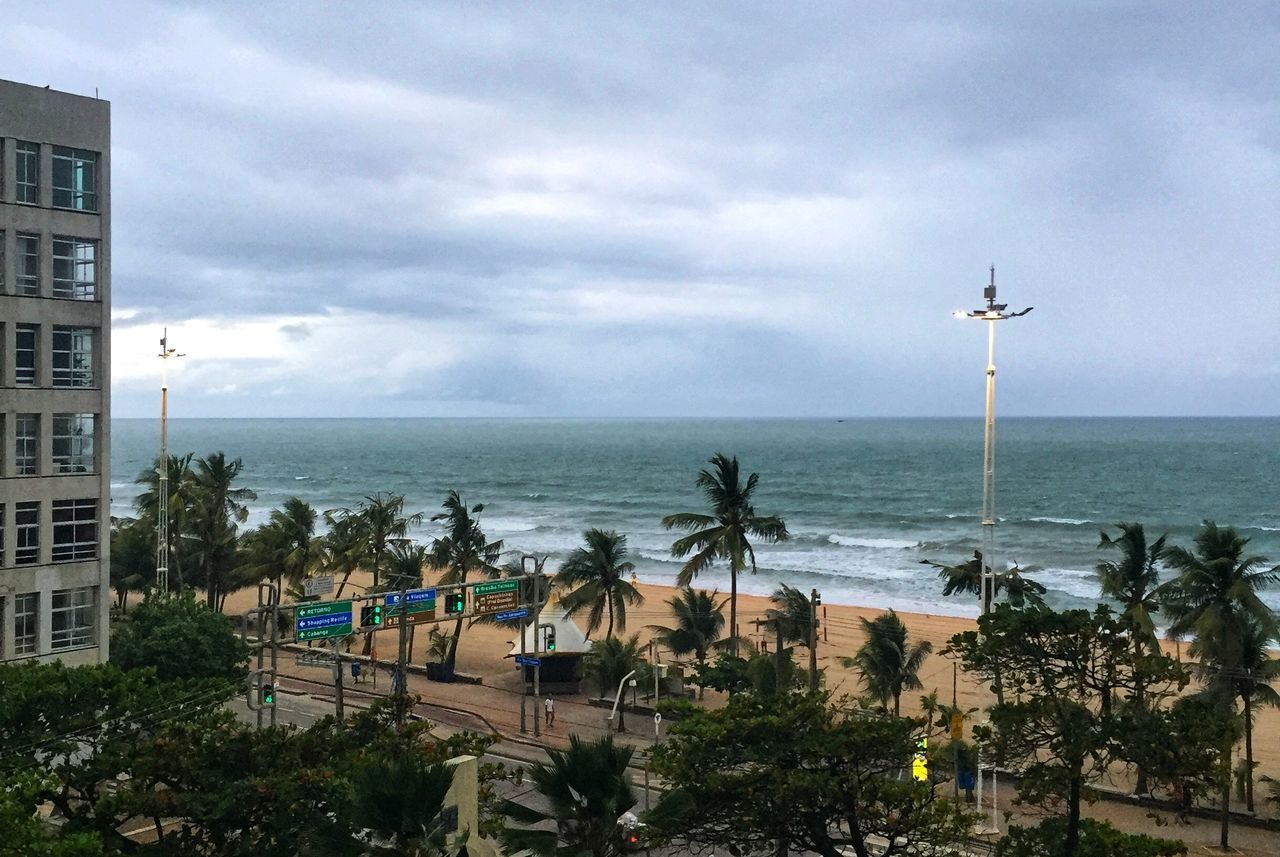 HIGH ANGLE VIEW OF BUILDING AND SEA AGAINST SKY