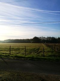 Road by field against sky