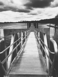 Empty pier over sea against sky