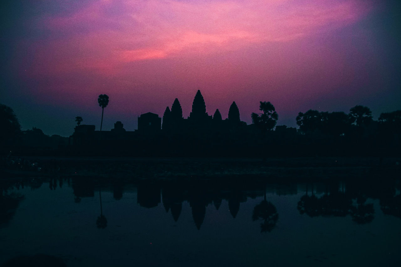 SILHOUETTE TEMPLE BY LAKE AGAINST SKY AT SUNSET