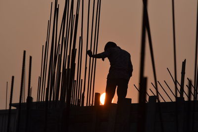 Silhouette man standing against orange sky