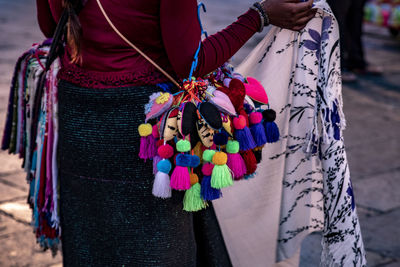 Midsection of woman holding multi colored souvenirs 