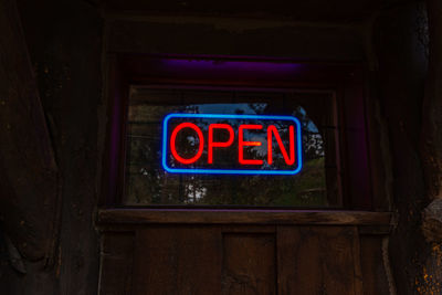 Low angle view of illuminated sign at store