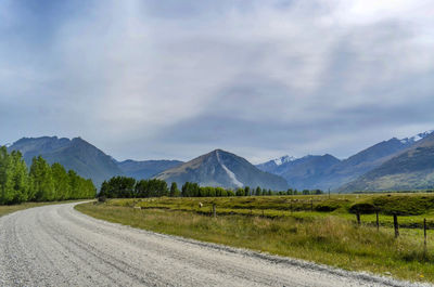 Road by mountains against sky