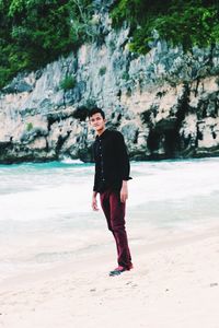 Full length portrait of man standing on beach